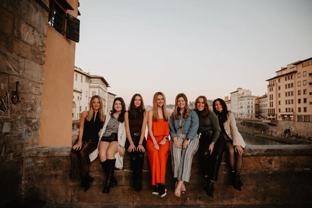 AIFS Abroad A group of friends sat on a wall with a backdrop fo the city