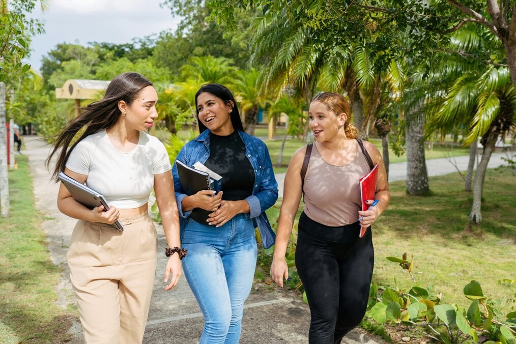 Photo by Gabrielle Henderson on Unsplash Three women college students walk together and laugh.