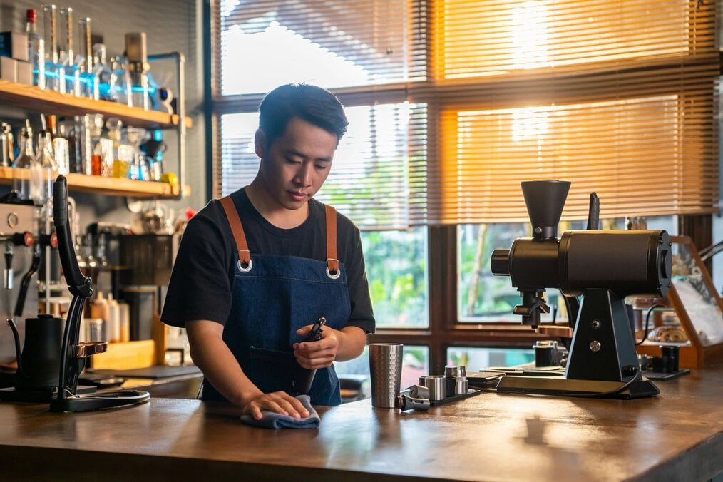 Unsplash worker A man works behind a counter at a cafe.
