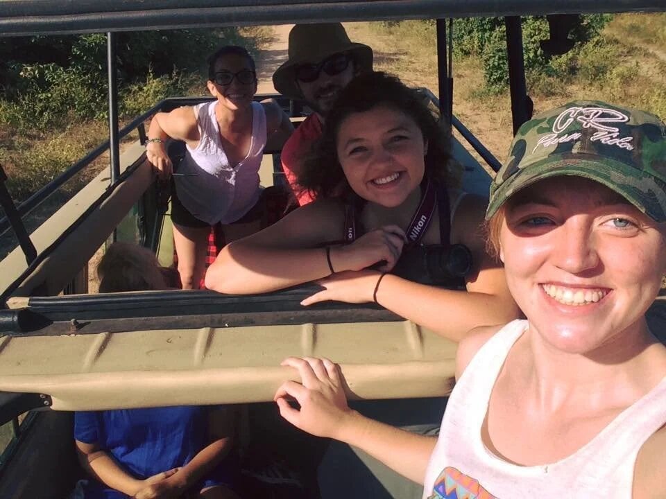 PA Several people inside of a safari jeep smile.