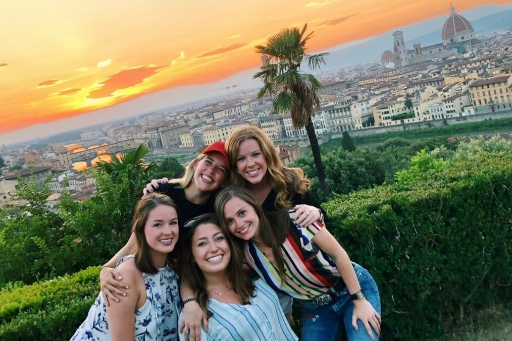 SAI study abroad Five friends posing in front of a city view and sunset